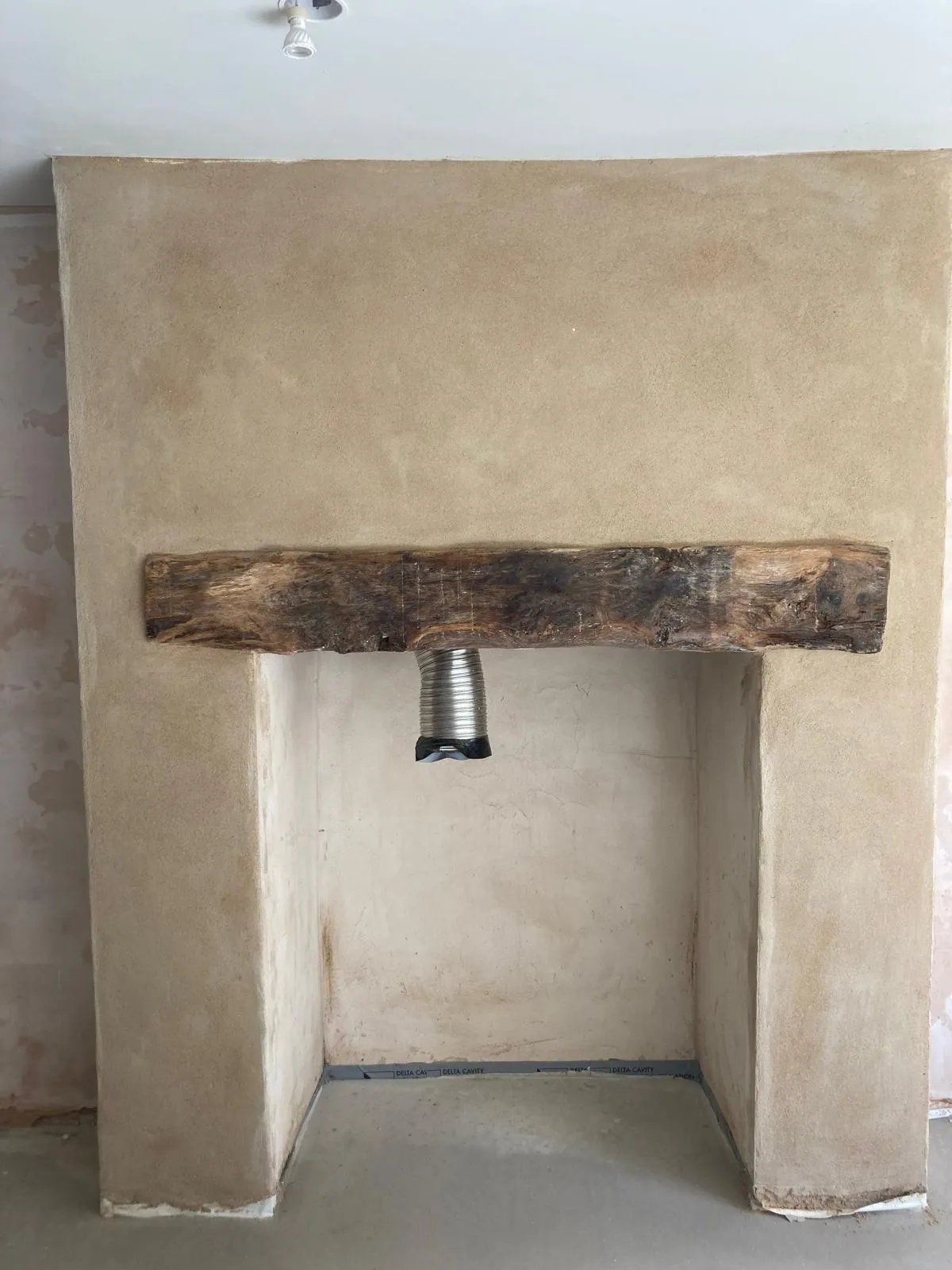 Freshly lime-rendered interior wall, a classic fireplace in keeping with the property