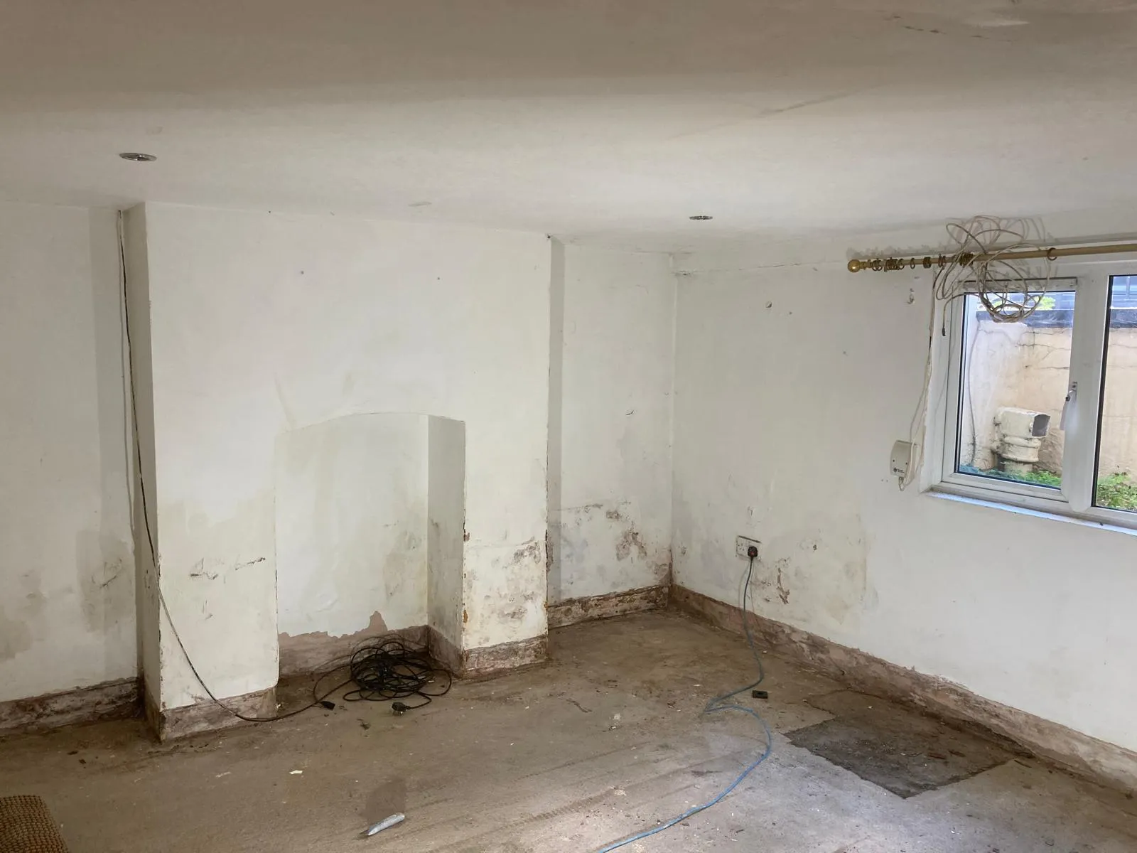 Basement floor screed with exposed service pipes during conversion