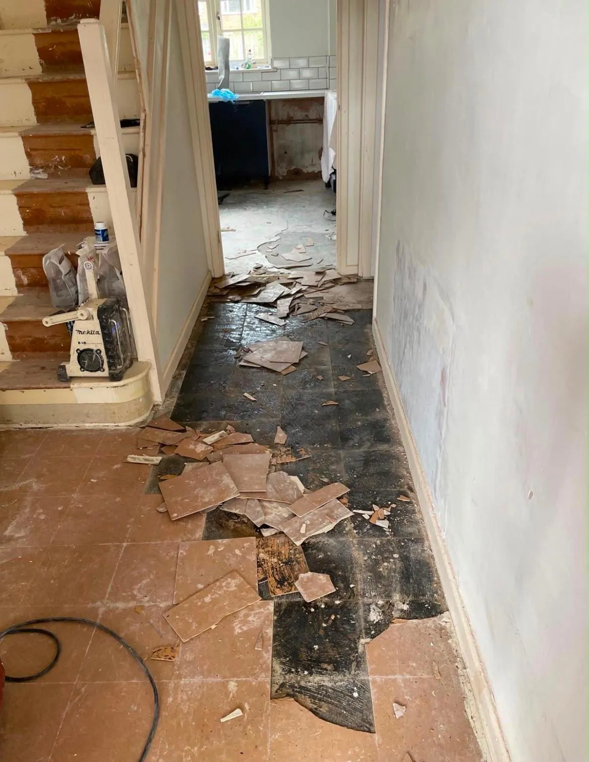 Entranceway floor tiles lifted to expose the subfloor