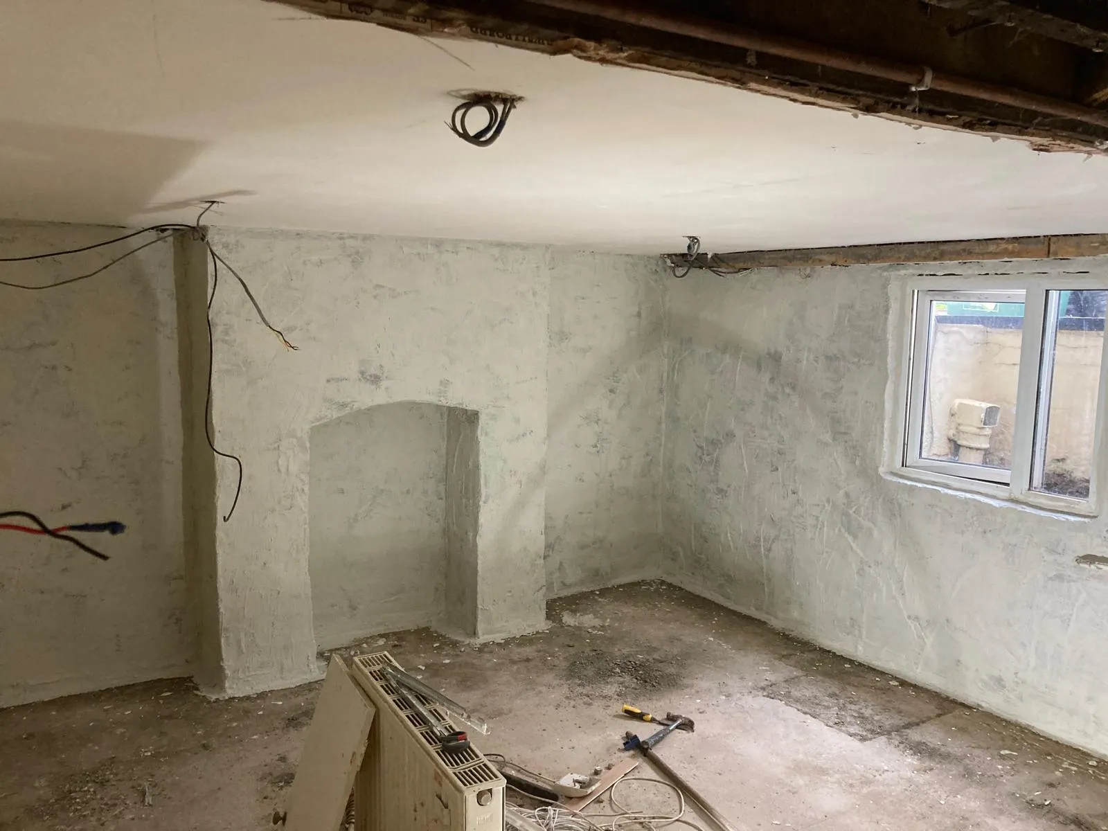 Basement wall with fitted drainage channel and damp-proof membrane edge