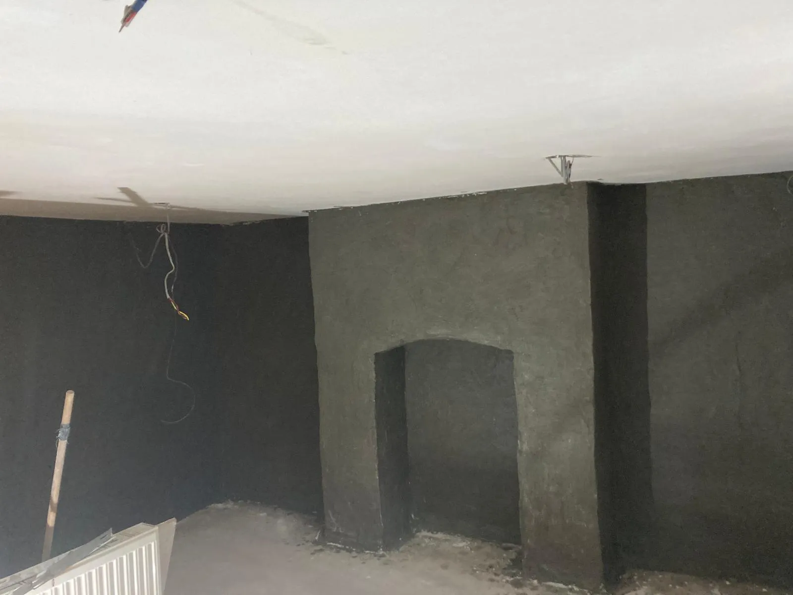 Basement floor with fresh screed and exposed service pipes