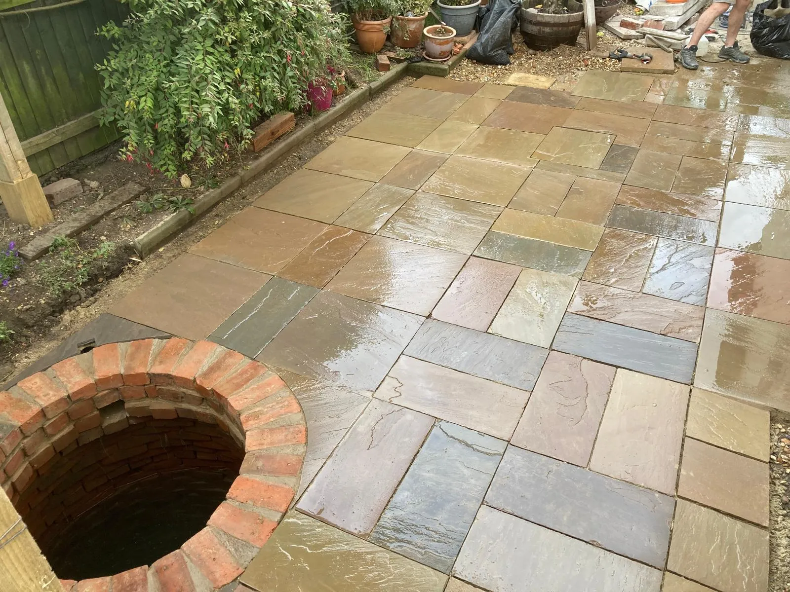 Newly laid sandstone patio with brick well surround