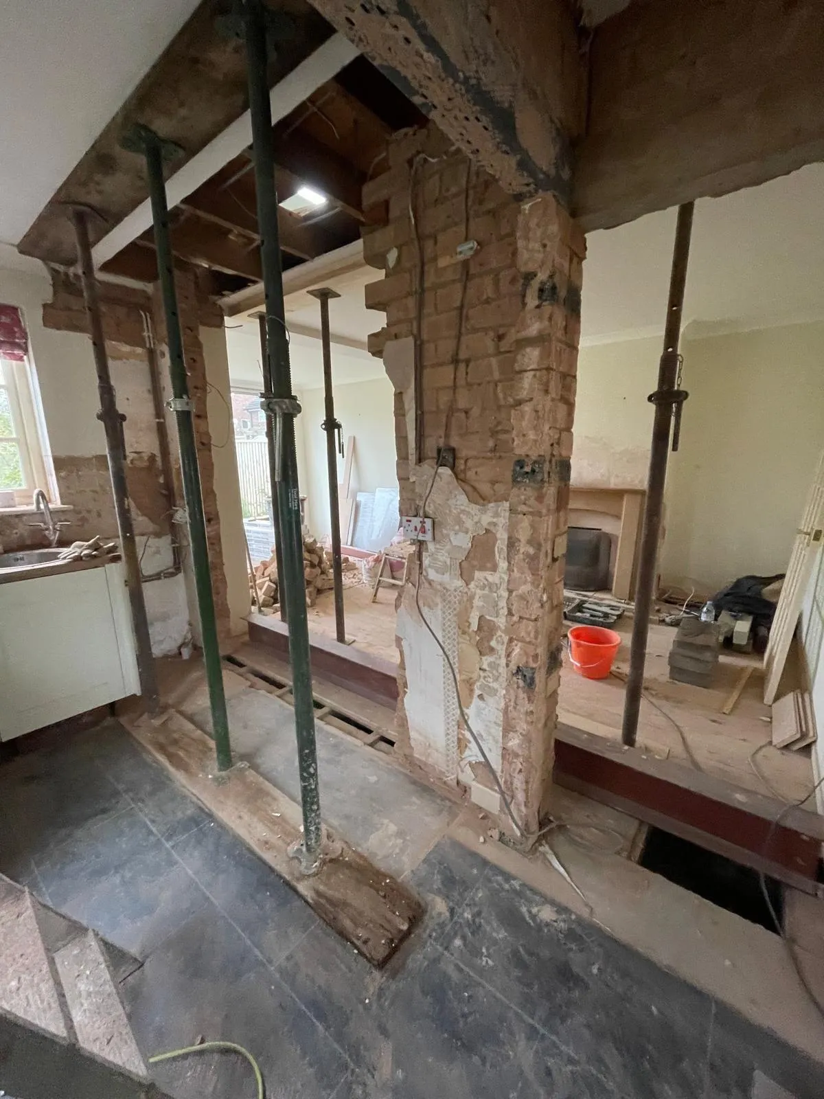 Load-bearing wall opened up with floor props and exposed brickwork
