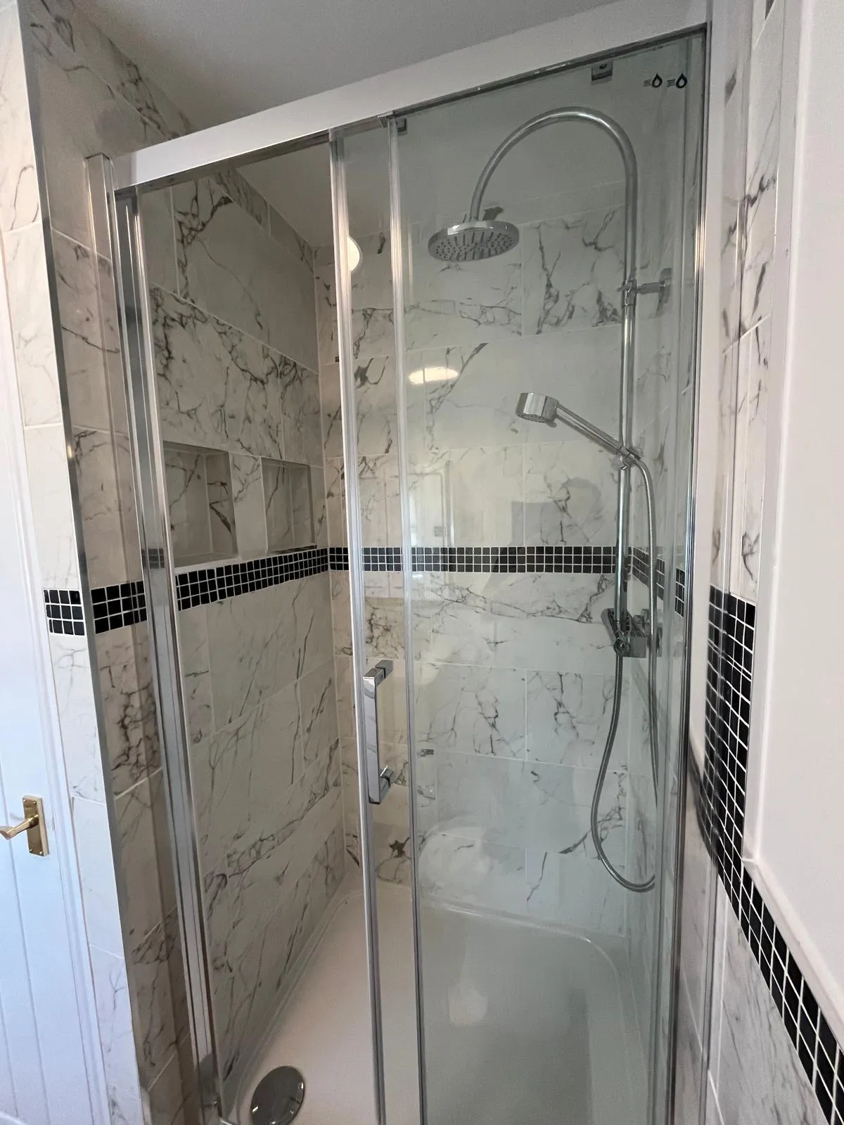 Newly fitted bathroom with white suite and tiled walls