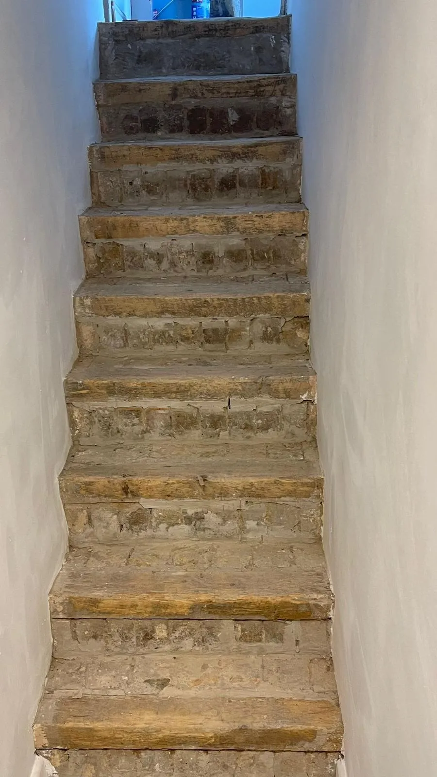 Worn brick staircase stripped of tiles during renovation works