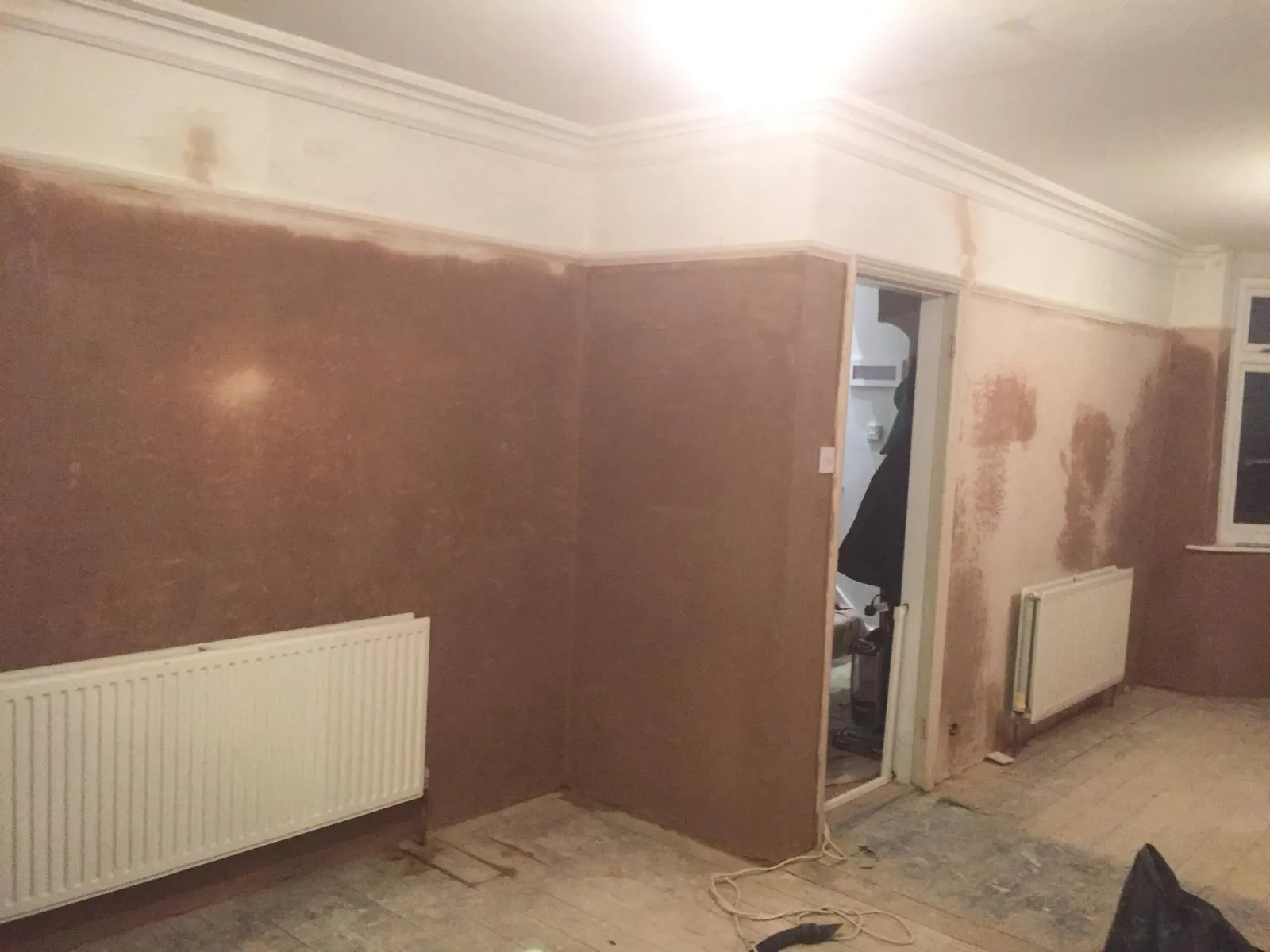 Plasterer skimming and sealing under brickwork