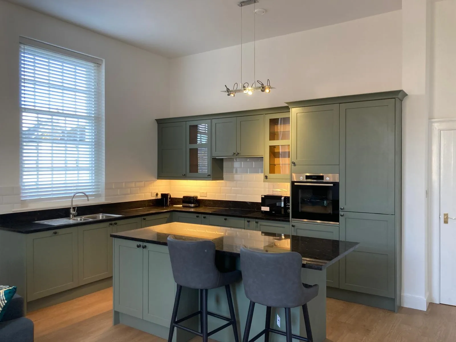 Newly fitted sage green kitchen & breakfast bar with integrated appliances