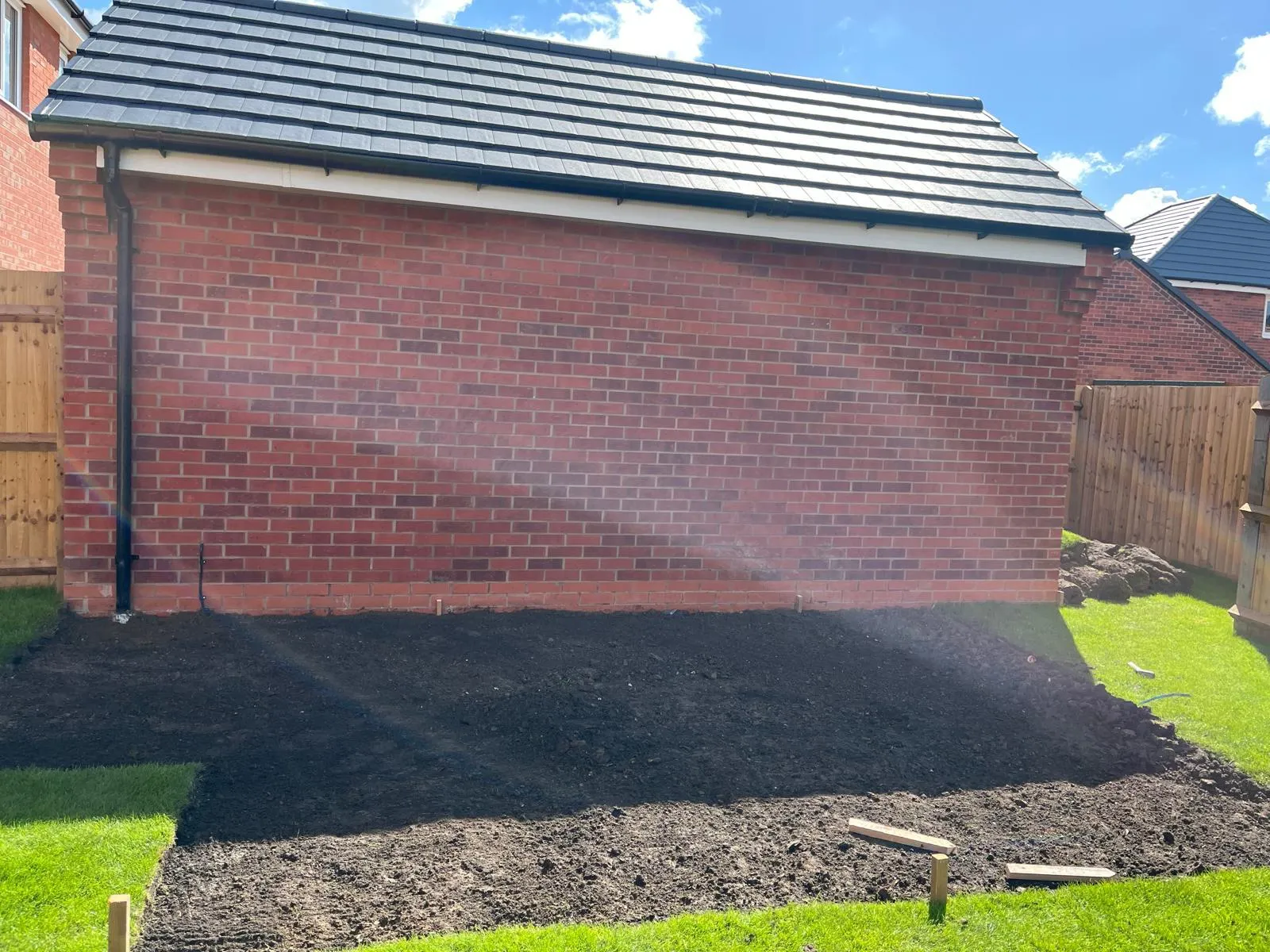 Garden with newly laid lawn, stepping stones and sleeper steps